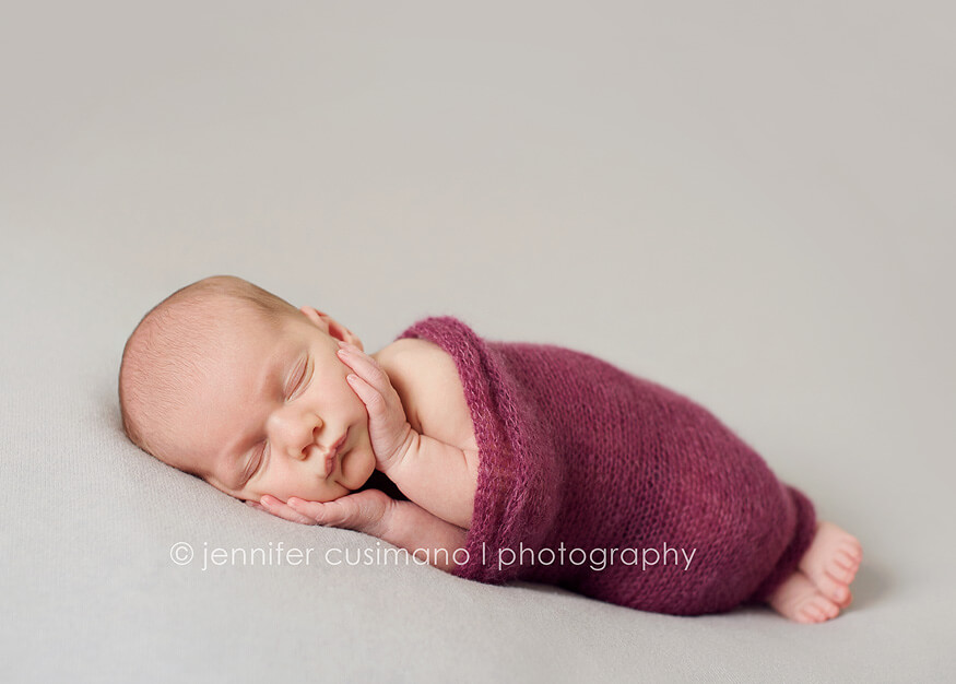newborn baby with a purple wrap