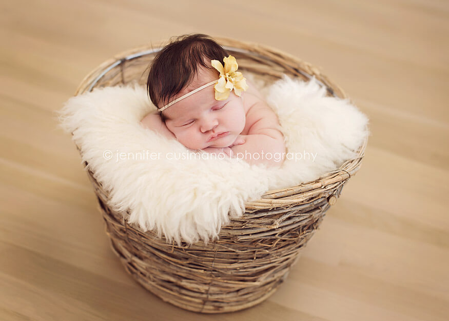 baby girl with yellow flower in a basket