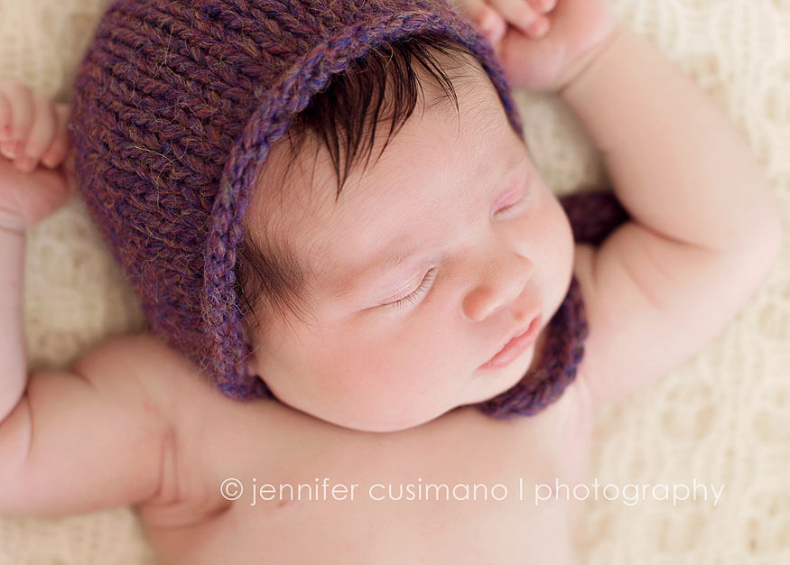 newborn baby girl with plum bonnet