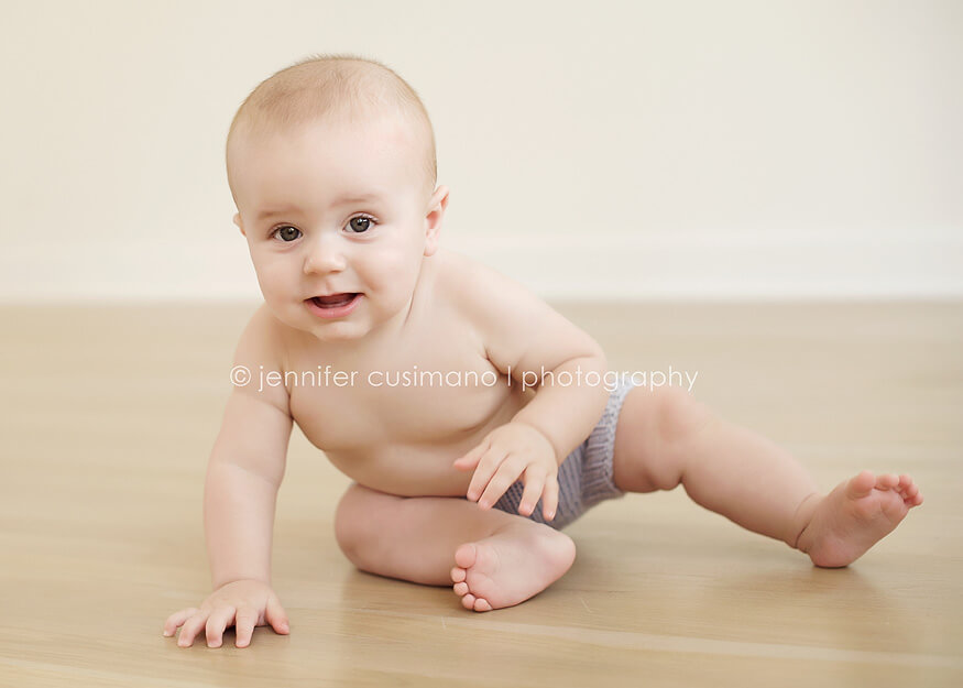 baby boy playing on wood floors in natural light studio in Houstoon