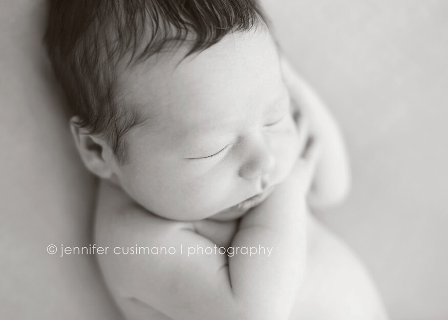 black and white image of a newborn baby boy sleeping in a natural light studio