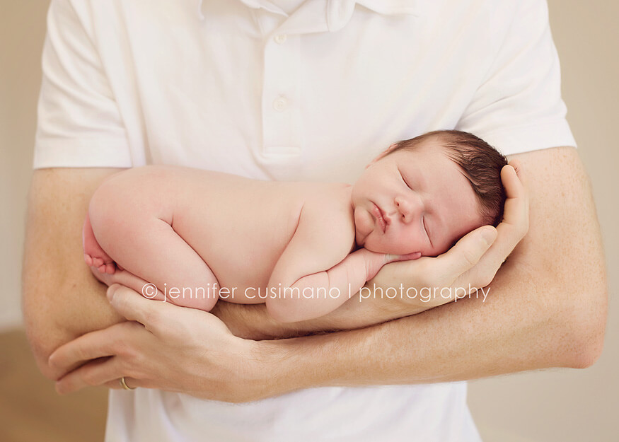 newborn baby in his dad's arms